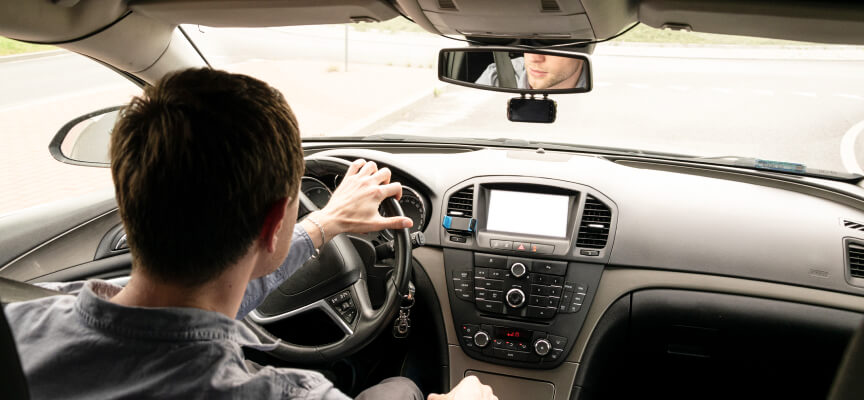 Back view of man driving a car