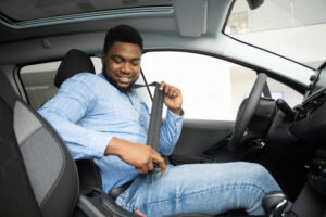 african american man buckling seat belt in car