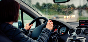 person driving car while it's raining