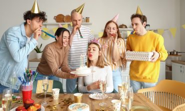 Friends celebrate a birthday together while exploring what age does car insurance get cheaper.