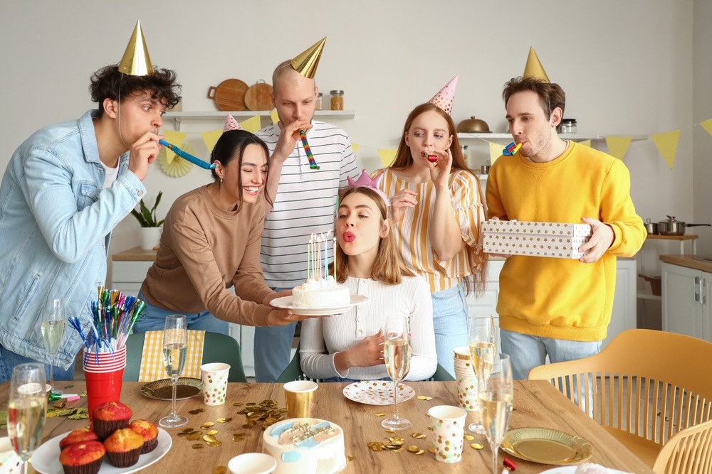 Friends celebrate a birthday together while exploring what age does car insurance get cheaper.