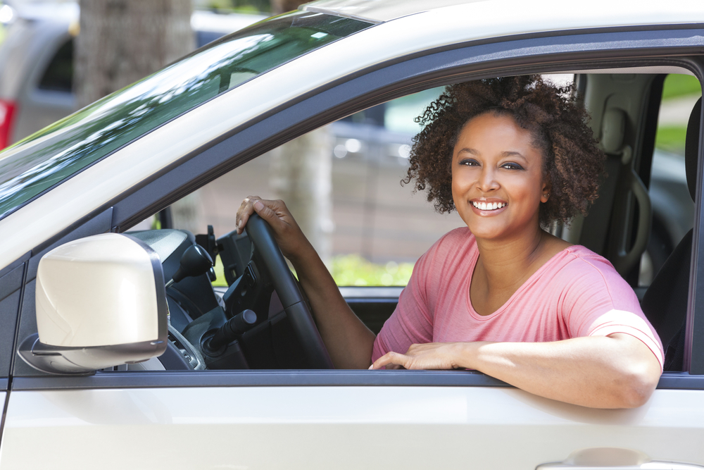 middle aged african american woman in drivers seat of car smiling