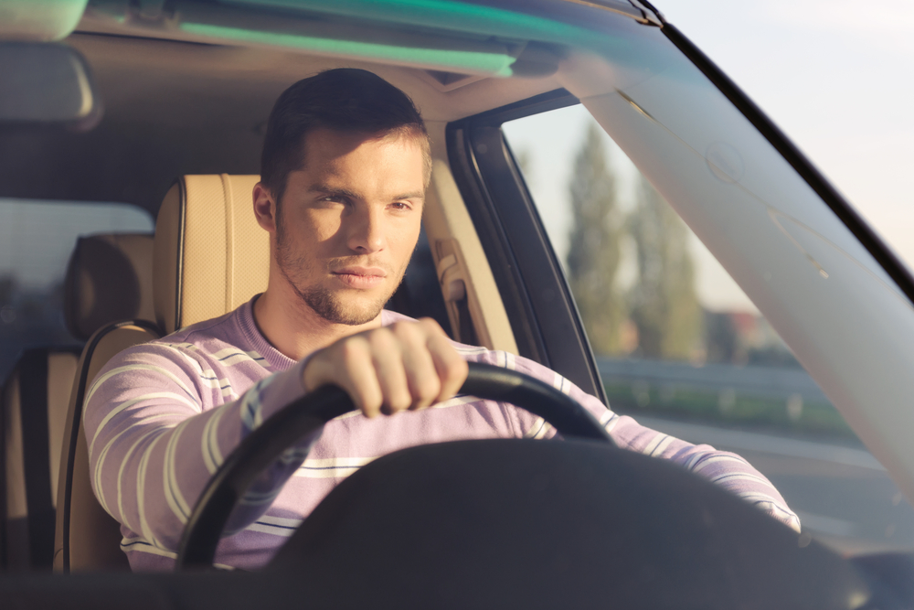 young caucasian male driving car concentrating