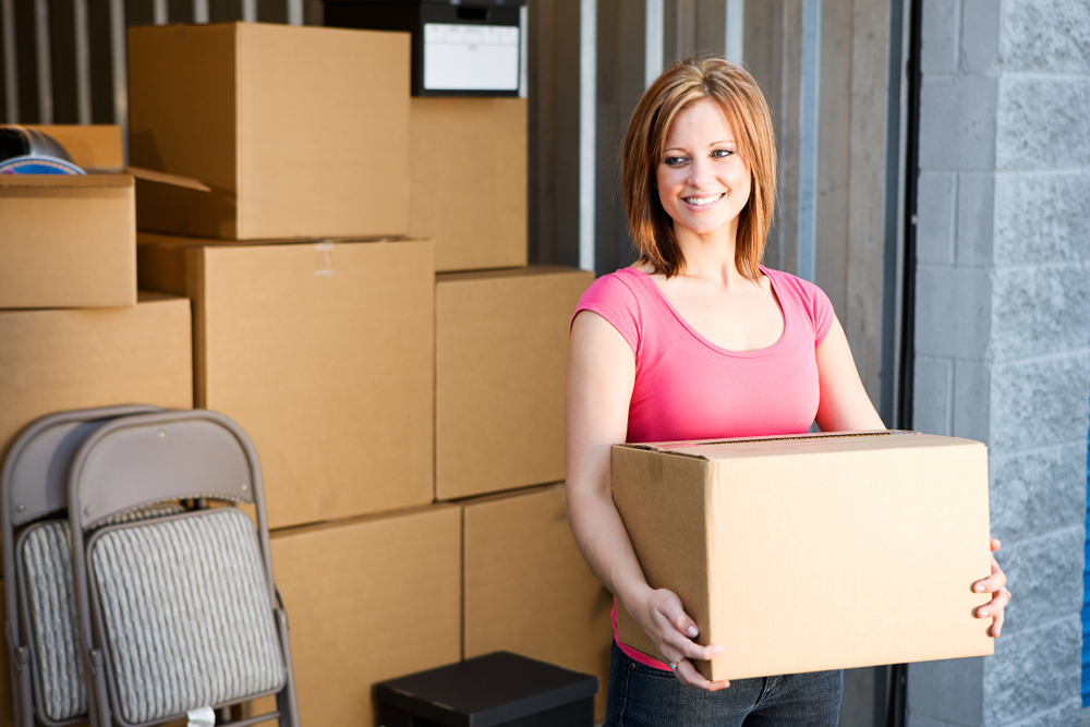 woman holding boxes outside of storage unit