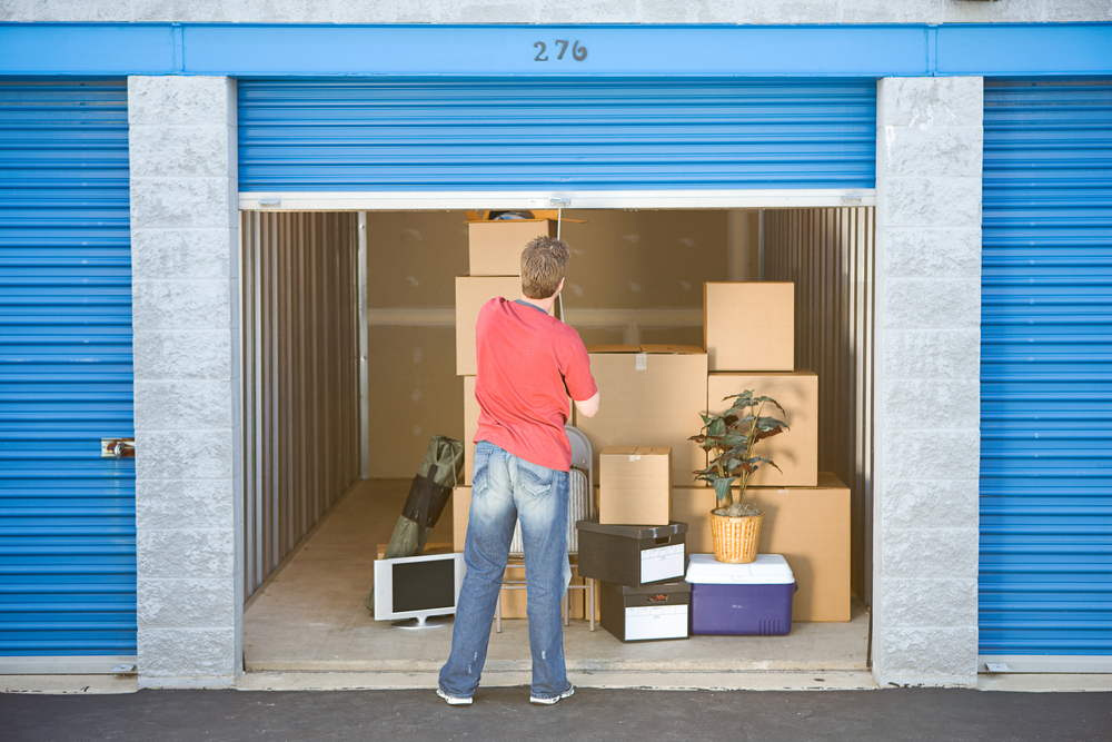 man shutting door on storage unit