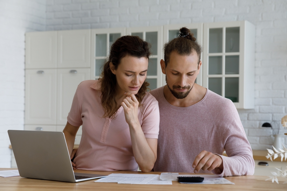 couple sitting at table reviewing auto insurance policy