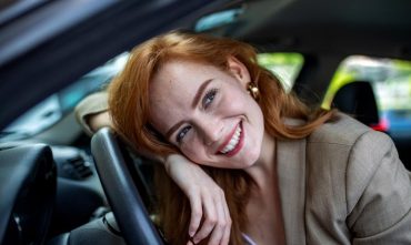 Woman smiling from the driver’s seat, creating a confident everyday driving moment for comprehensive car insurance in Georgia.