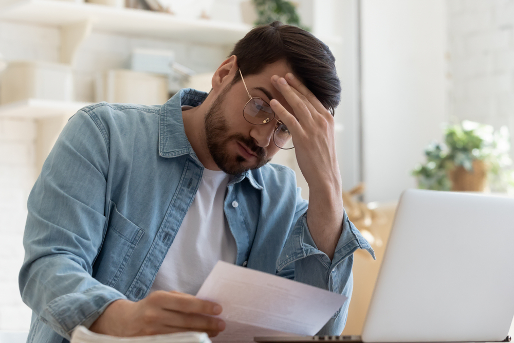 man looking over documents near computer