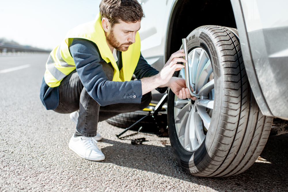 roadside assistance service man putting on new tire