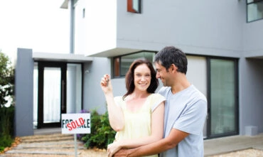 couple standing outside of newly bought home