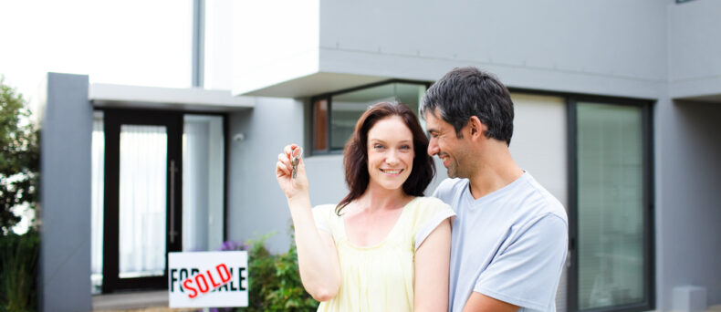 couple standing outside of newly bought home