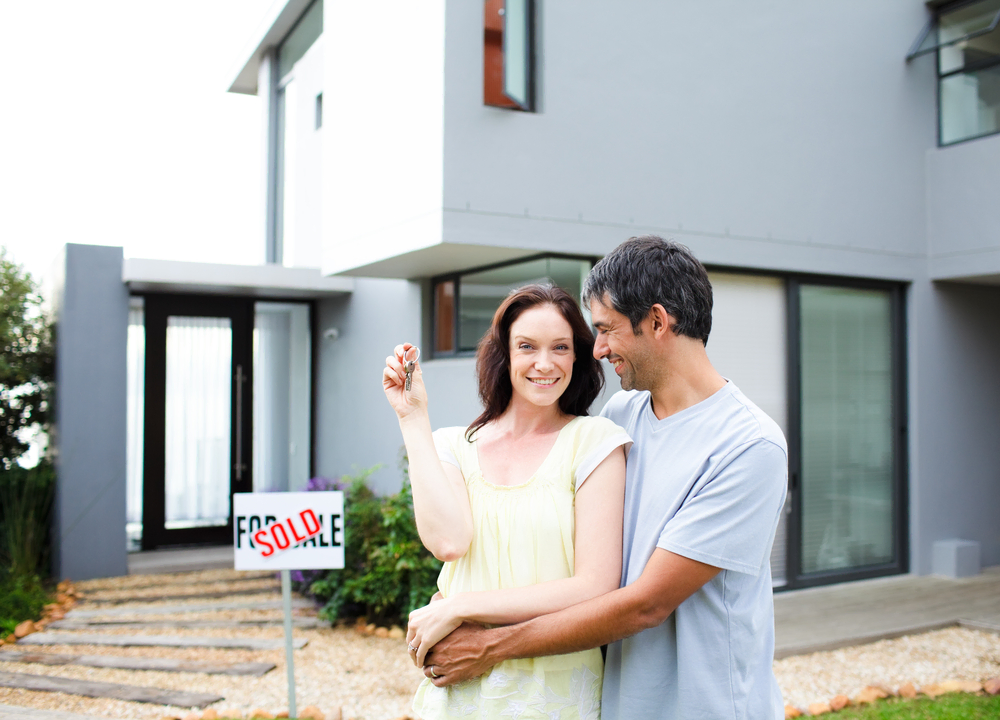 couple standing outside of newly bought home