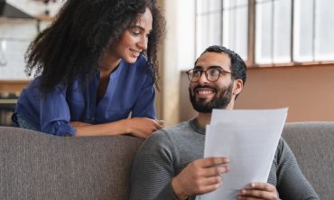 Couple reviewing paperwork at home, emphasizing why Atlanta renters need insurance for financial protection.