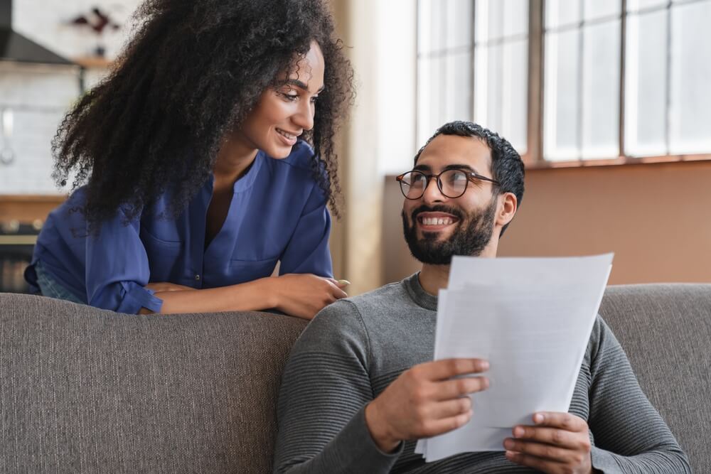 Couple reviewing paperwork at home, emphasizing why Atlanta renters need insurance for financial protection.