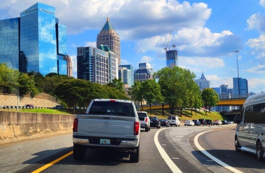 Cars driving on a busy city highway in Georgia, illustrating savings and flexibility when you switch car insurance for daily commuting.