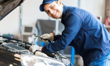 Smiling mechanic works under the hood