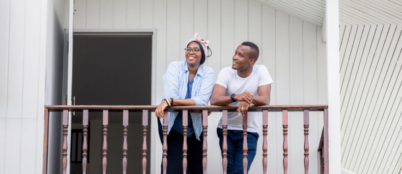 African American couple thinks about getting renters insurance while standing on the balcony of their apartment