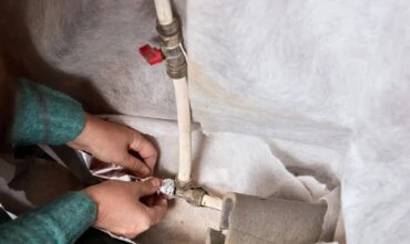 hands wrap pipes before a freeze