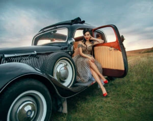 Beautiful lady sits inside a classic car