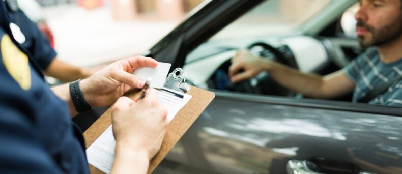 man gets a ticket from a police officer for speeding