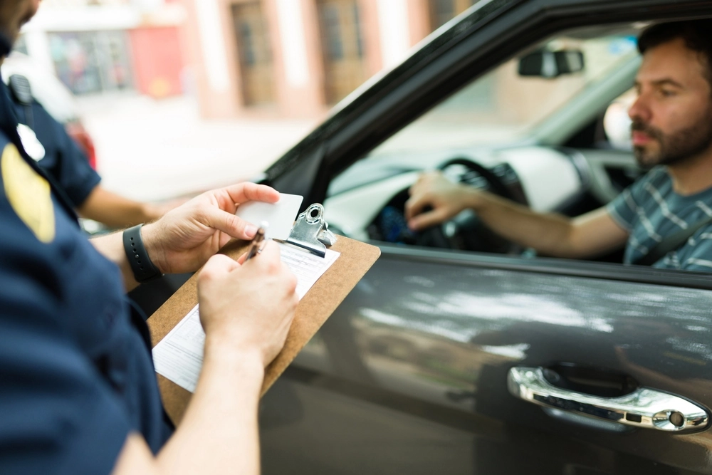 man gets a ticket from a police officer for speeding