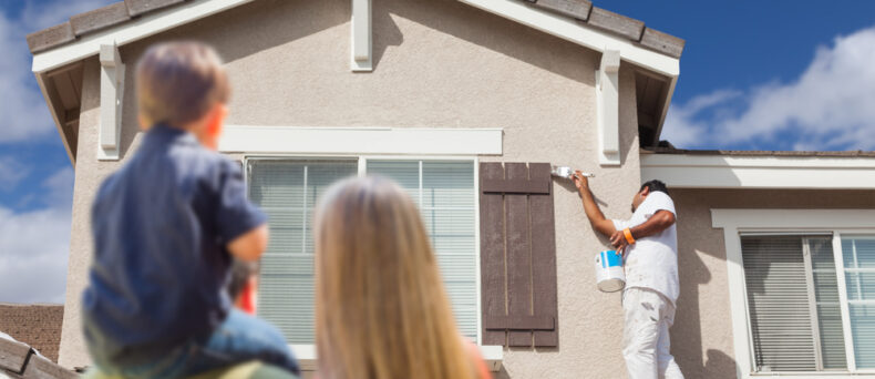 Young family watches as painters improve curb appeal of home before selling