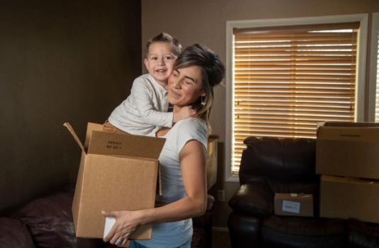 Woman apcking up clutter while staging her home for sale