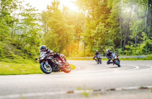 Bikers on a curvy road in the forest