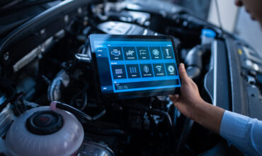 Mechanic uses computer to diagnose car maintenance costs in Georgia