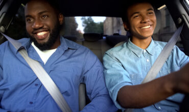Father and teen son drive in car