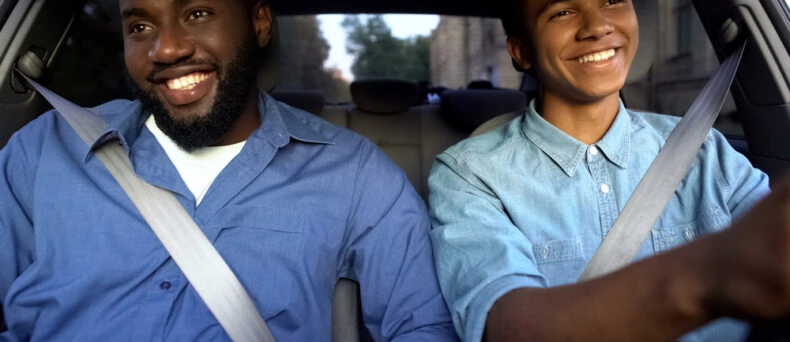 Father and teen son drive in car
