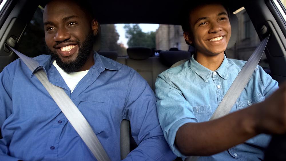 Father and teen son drive in car