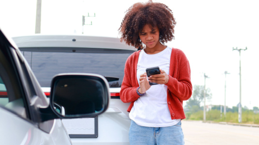 Young African-American woman calls her insurance company after a car wreck