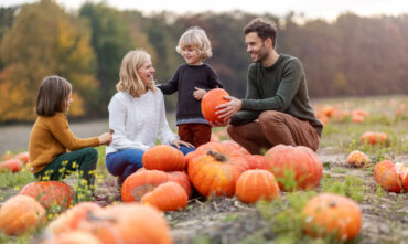 Family picking a pumpkin from the pumpkin patch