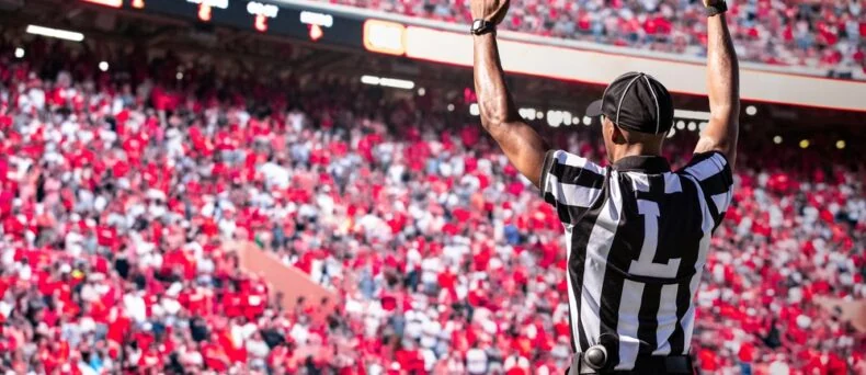 Referee signals a touchdown at a football game - car insurance in Georgia
