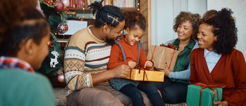 Happy African American multigeneration family enjoying in opening gifts on Christmas day at home.