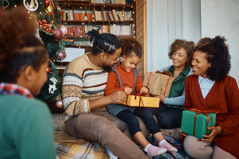 Happy African American multigeneration family enjoying in opening gifts on Christmas day at home.