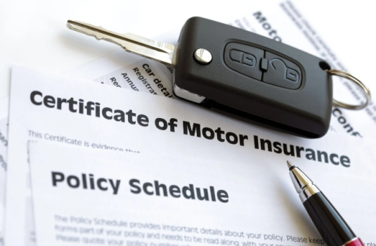 Car key on top of car insurance paperwork - cheap car insurance in Georgia.