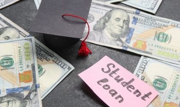 Graduation cap, U.S. dollar bills, and a note reading student loan, illustrating the financial reality of student loans in Georgia.
