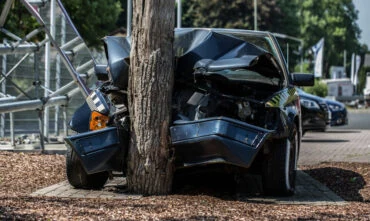 Front view of a car crashed into a tree, cheap car insurance in Georgia.