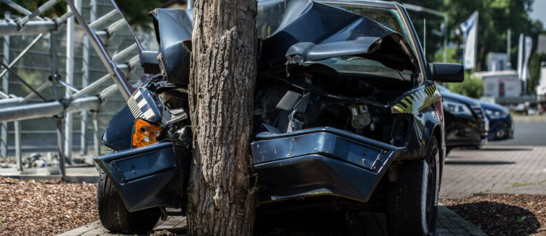 Front view of a car crashed into a tree, cheap car insurance in Georgia.