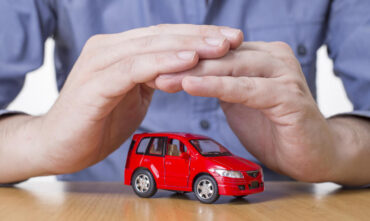 Image of hands making a shelter over a new car, Gap insurance.