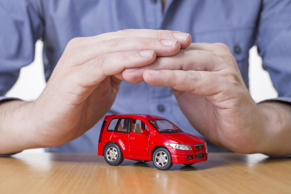 Image of hands making a shelter over a new car, Gap insurance.