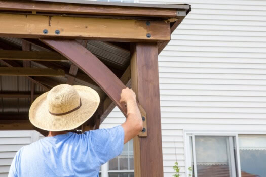 Homeowner does maintenance on his wood deck supports - cheap home insurance in Georgia.