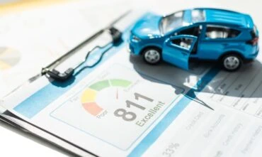 Blue toy car on a credit score document - Cheap car insurance in Georgia