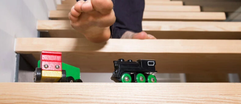 Person's foot on steps, about to step on a toy and fall - cheap home insurance in Georgia.
