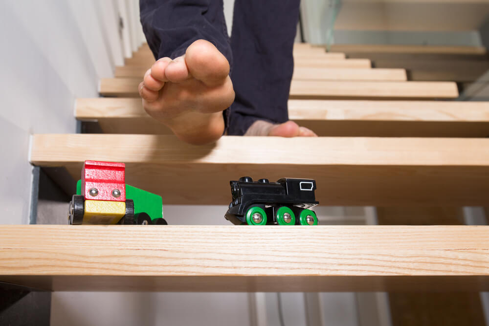 Person's foot on steps, about to step on a toy and fall - cheap home insurance in Georgia.