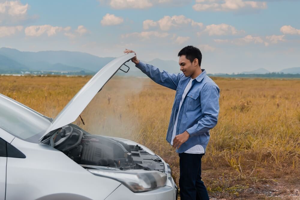 Man opens car hood because it is overheated - Southern Harvest Cheap homeowners in Georgia.