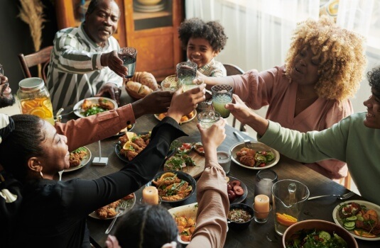 Happy family at thanksgiving smiling raising glasses.