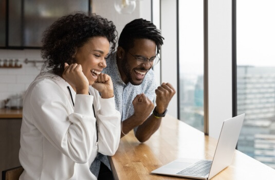 Young couple celebrating as they find a cheaper home insurance in Georgia.